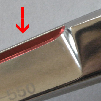 Roter Pfeil zeigt auf die stumpfe und beschädigte Klinge einer Mizutani Schere als Illustration der Gefahren durch einen externen Schleifservice